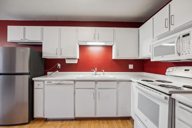 kitchen featuring white cabinetry, sink, white appliances, a textured ceiling, and light hardwood / wood-style flooring