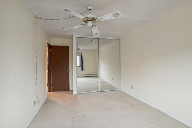 unfurnished bedroom featuring a baseboard heating unit, light colored carpet, a closet, and ceiling fan