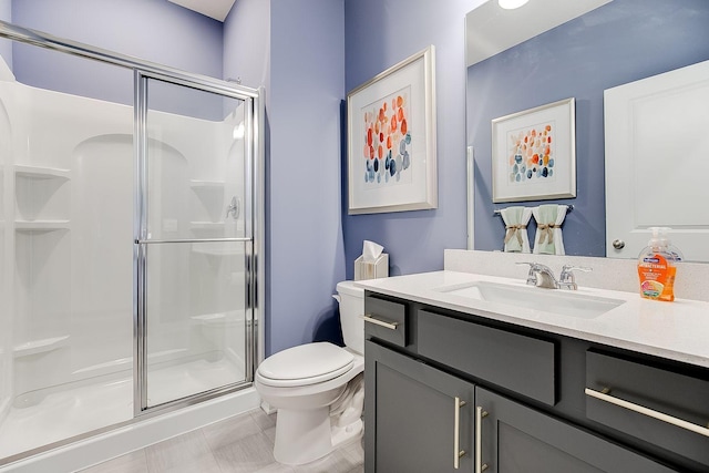 bathroom with tile patterned floors, vanity, toilet, and a shower with shower door