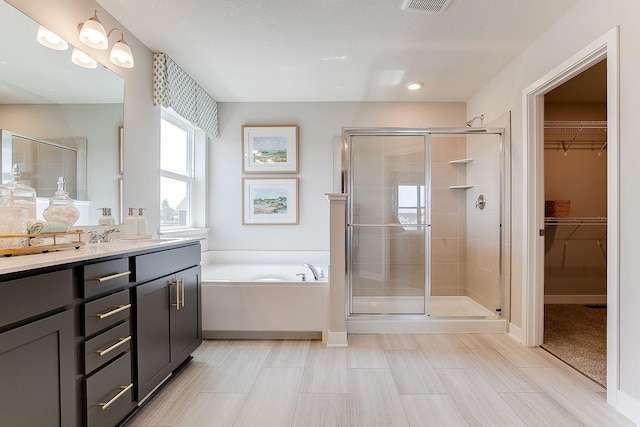 bathroom featuring vanity and independent shower and bath