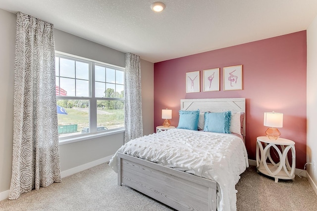 bedroom with carpet, a textured ceiling, and multiple windows