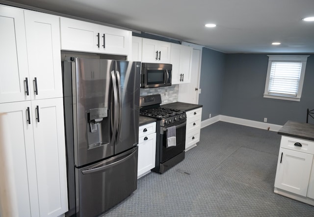 kitchen with stainless steel appliances, white cabinets, decorative backsplash, and dark carpet