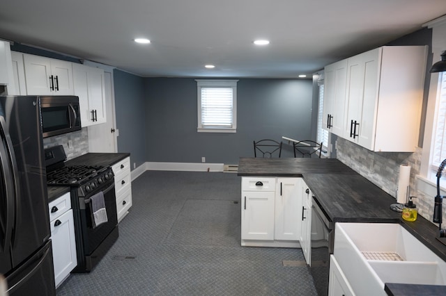 kitchen with black appliances, white cabinets, and backsplash