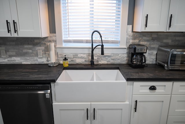 kitchen featuring sink, white cabinets, backsplash, and dishwashing machine