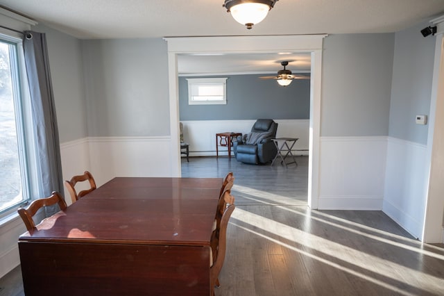 dining space featuring baseboard heating, ceiling fan, and dark hardwood / wood-style flooring