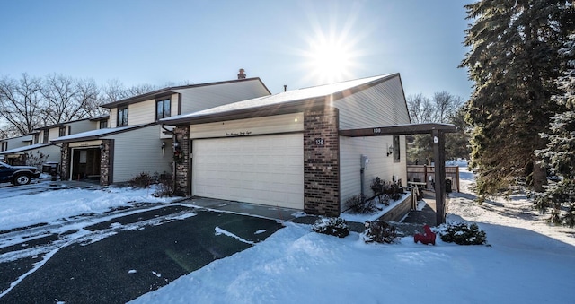 view of snow covered exterior featuring a garage