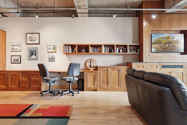 office area featuring light wood-type flooring, built in desk, and rail lighting