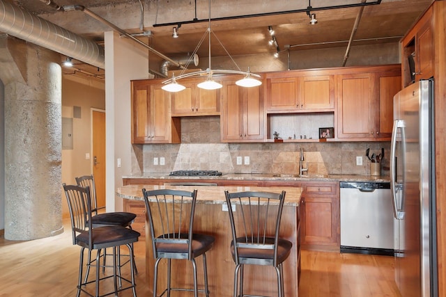 kitchen featuring sink, rail lighting, light hardwood / wood-style flooring, and appliances with stainless steel finishes