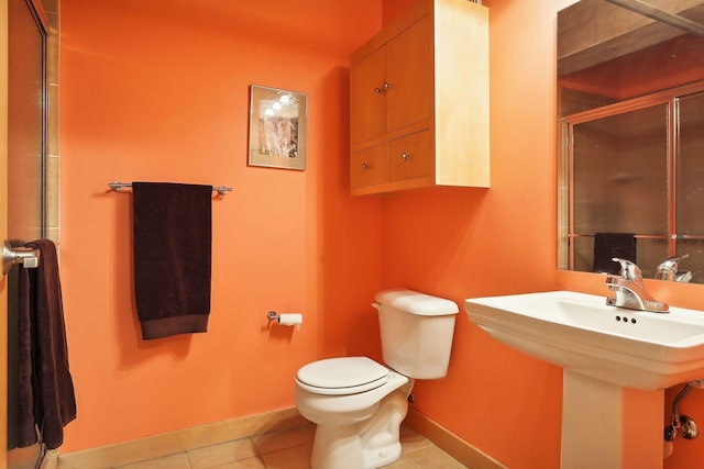 bathroom featuring tile patterned floors, sink, an enclosed shower, and toilet