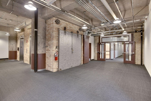 interior space with elevator and brick wall