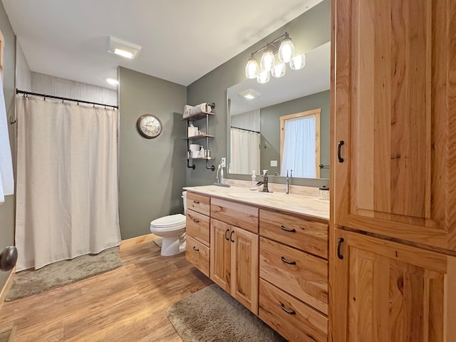 bathroom with toilet, vanity, and hardwood / wood-style flooring