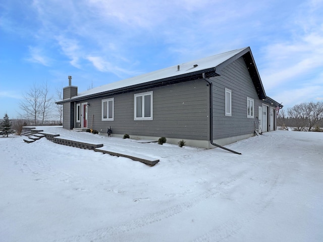 view of snow covered back of property