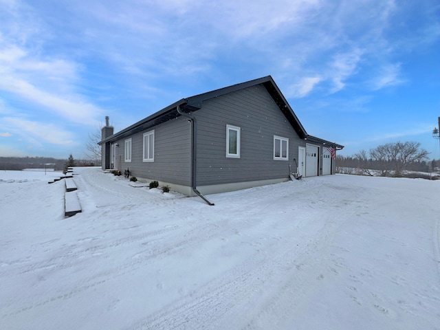 view of snow covered exterior featuring a garage