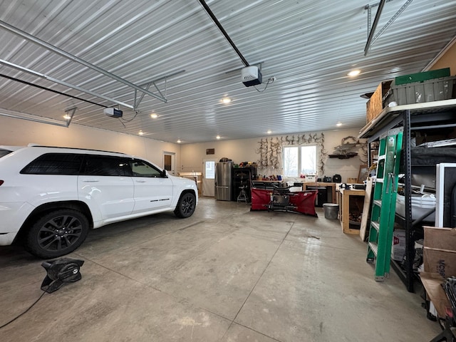 garage featuring a garage door opener and stainless steel refrigerator