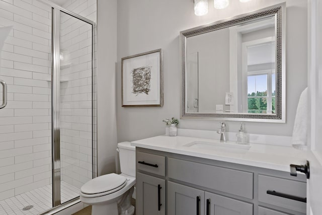 bathroom with toilet, vanity, and an enclosed shower