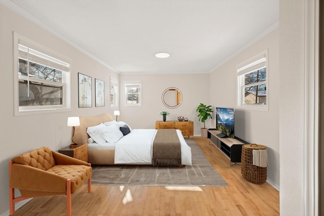 bedroom with light wood-type flooring and ornamental molding