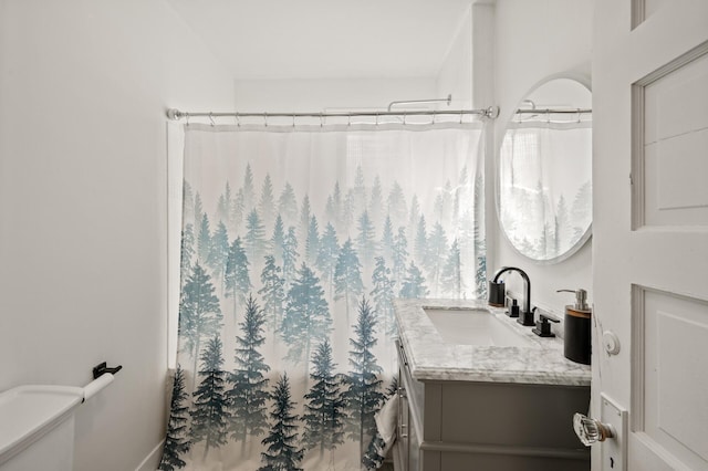 bathroom with toilet, vanity, and a shower with shower curtain