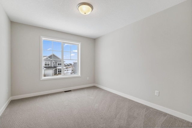 carpeted spare room featuring a textured ceiling