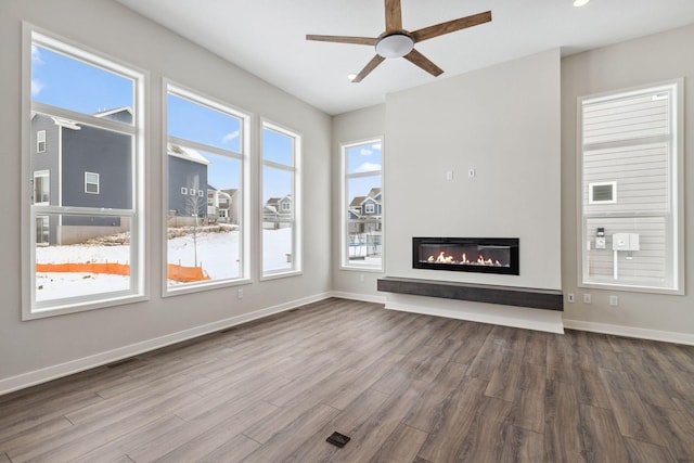 unfurnished living room with wood-type flooring and ceiling fan