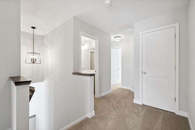 hallway featuring carpet and a chandelier