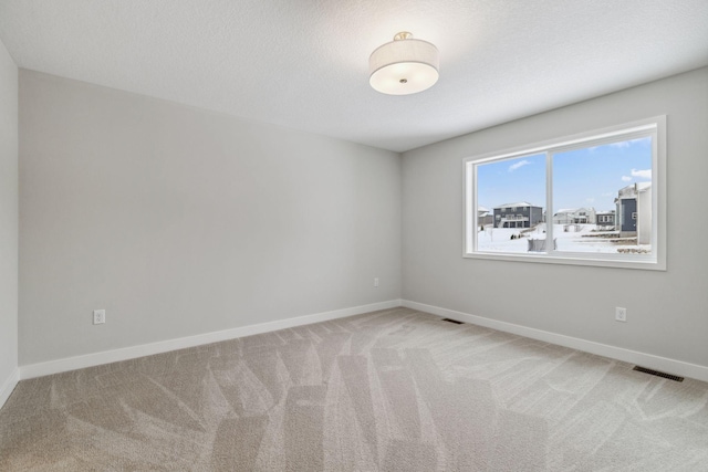 empty room featuring a textured ceiling and carpet