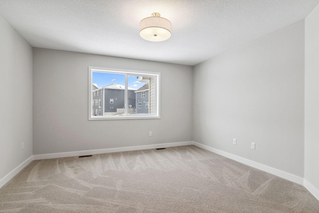 carpeted spare room featuring a textured ceiling