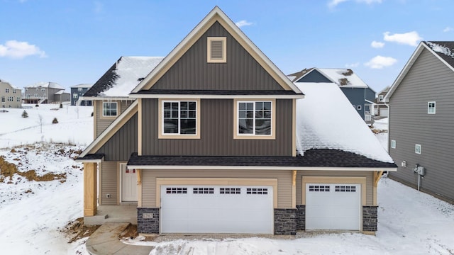 view of front of property with board and batten siding, stone siding, and a shingled roof