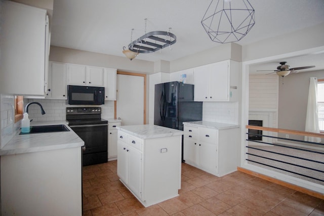 kitchen featuring a kitchen island, white cabinetry, black appliances, and sink