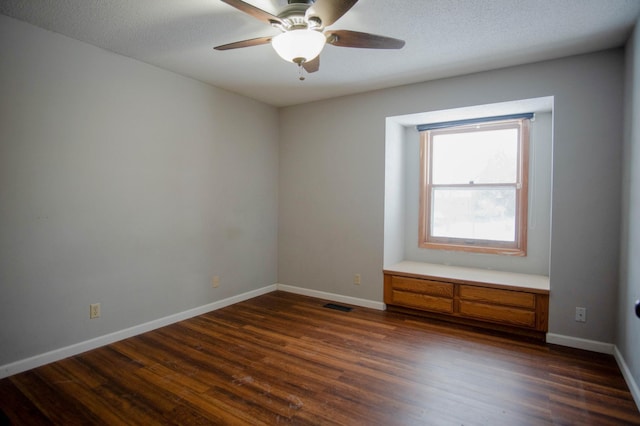 spare room featuring a textured ceiling, ceiling fan, and dark wood-type flooring