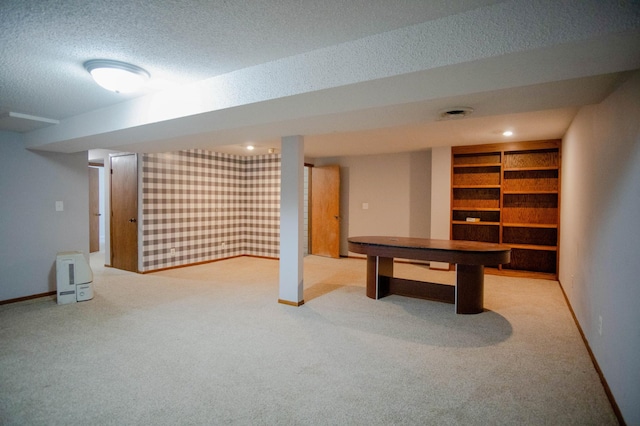 basement featuring a textured ceiling and light colored carpet