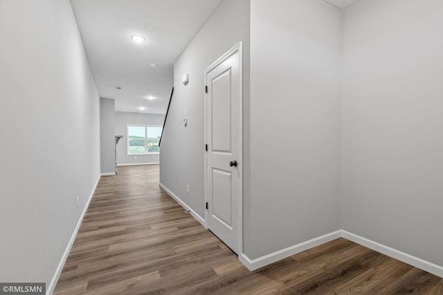 hallway with hardwood / wood-style flooring