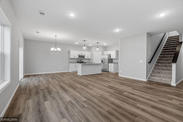 unfurnished living room featuring dark hardwood / wood-style flooring and a chandelier