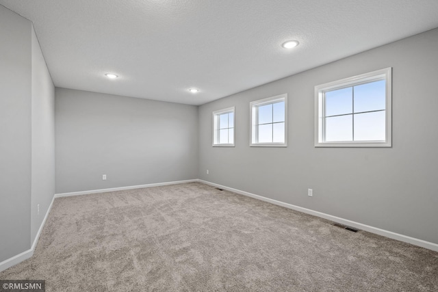 unfurnished room with a textured ceiling and carpet