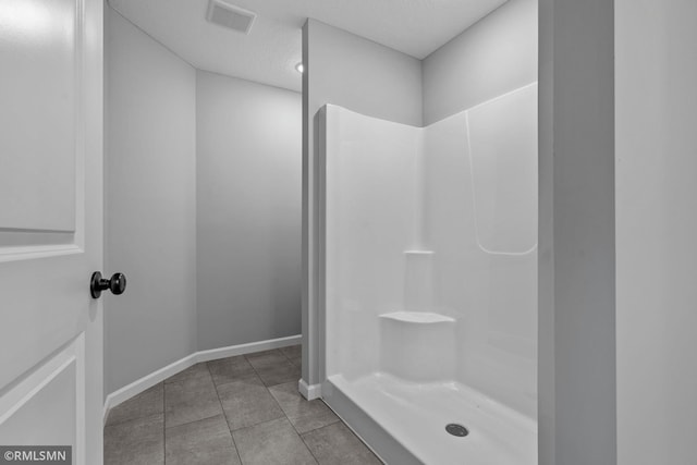 bathroom featuring a shower and a textured ceiling