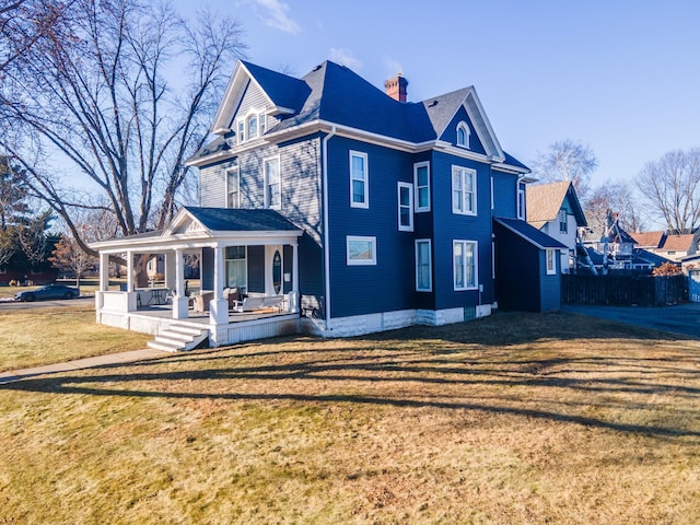 118 Chestnut St, Lake City, MN 55041 - view of home's exterior featuring a porch, a lawn, and a chimney