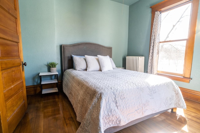 bedroom with radiator and dark hardwood / wood-style floors