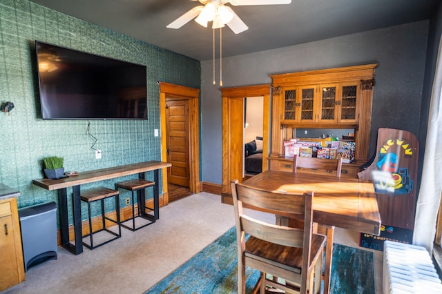 dining space with ceiling fan and light carpet