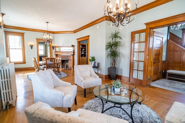 living room with light hardwood / wood-style floors, a brick fireplace, radiator, and crown molding