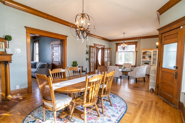 dining room with ornamental molding, light hardwood / wood-style flooring, radiator, and a chandelier