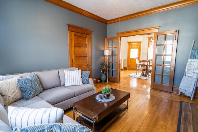 living room with french doors, wood-type flooring, a textured ceiling, and ornamental molding