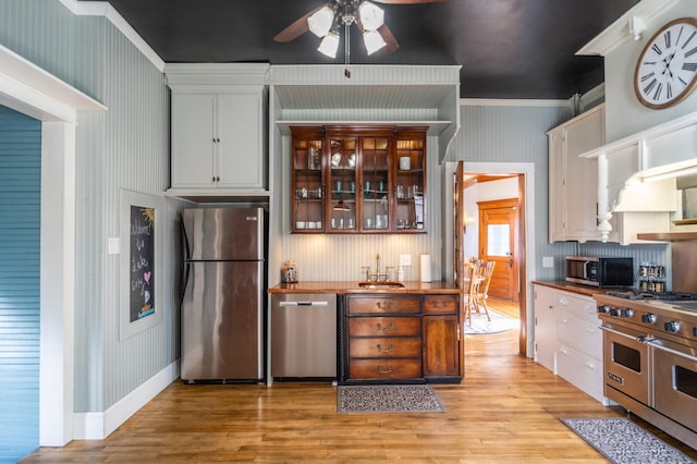 118 Chestnut St, Lake City, MN 55041 - kitchen with appliances with stainless steel finishes, a ceiling fan, light wood-type flooring, ornamental molding, and glass insert cabinets