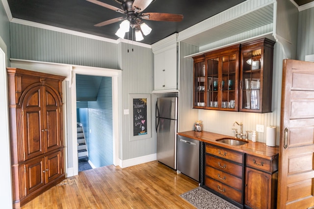 kitchen featuring ceiling fan, sink, wood counters, appliances with stainless steel finishes, and light wood-type flooring