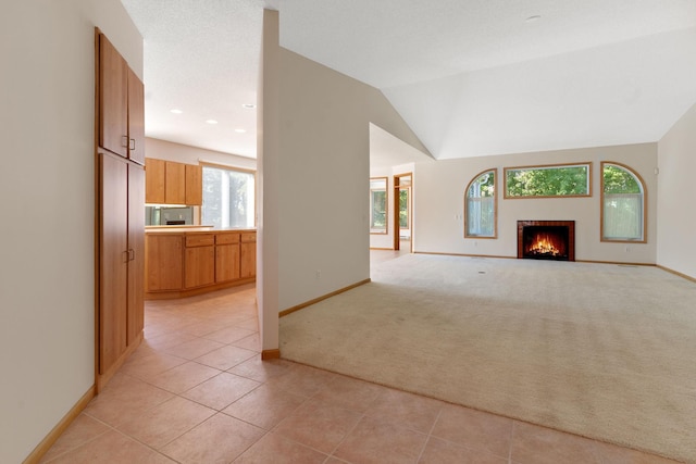 unfurnished living room with light colored carpet and vaulted ceiling