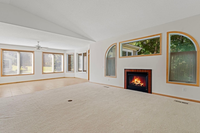 unfurnished living room featuring carpet flooring, a wealth of natural light, ceiling fan, and lofted ceiling