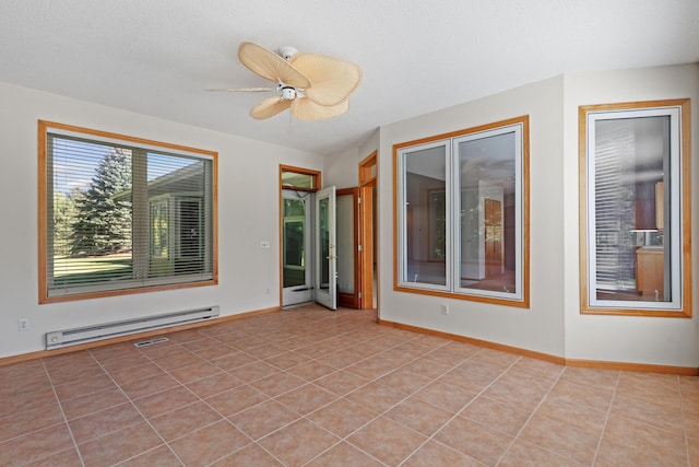 tiled spare room with ceiling fan and a baseboard heating unit