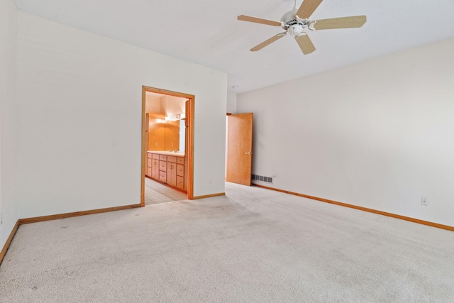 empty room featuring ceiling fan and light colored carpet