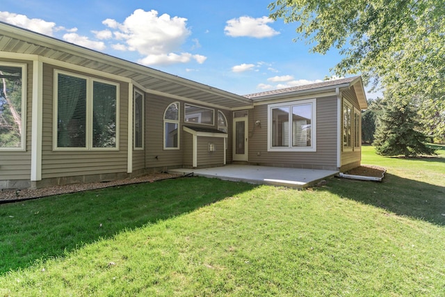 rear view of house with a yard and a patio