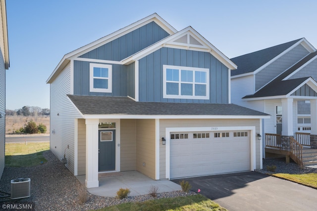 view of front of property featuring a garage and central AC