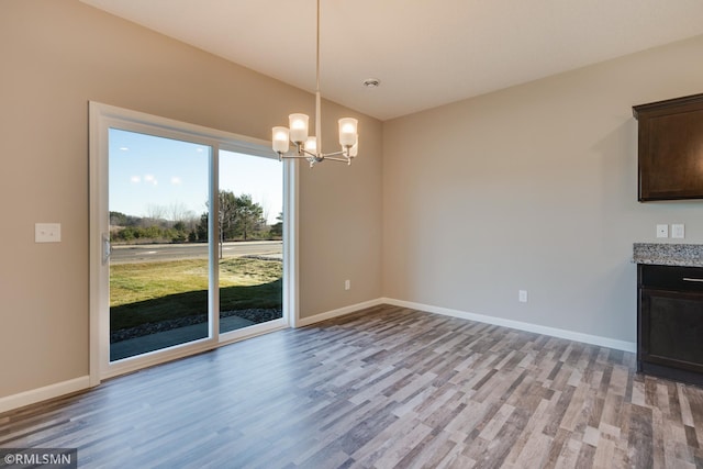 unfurnished dining area with light wood-type flooring and a chandelier