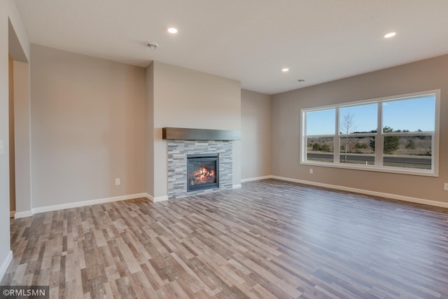 unfurnished living room featuring light wood-type flooring and a tile fireplace